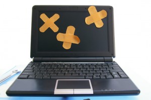 laptop computer with bandages - computer repair, or online healthcare concept